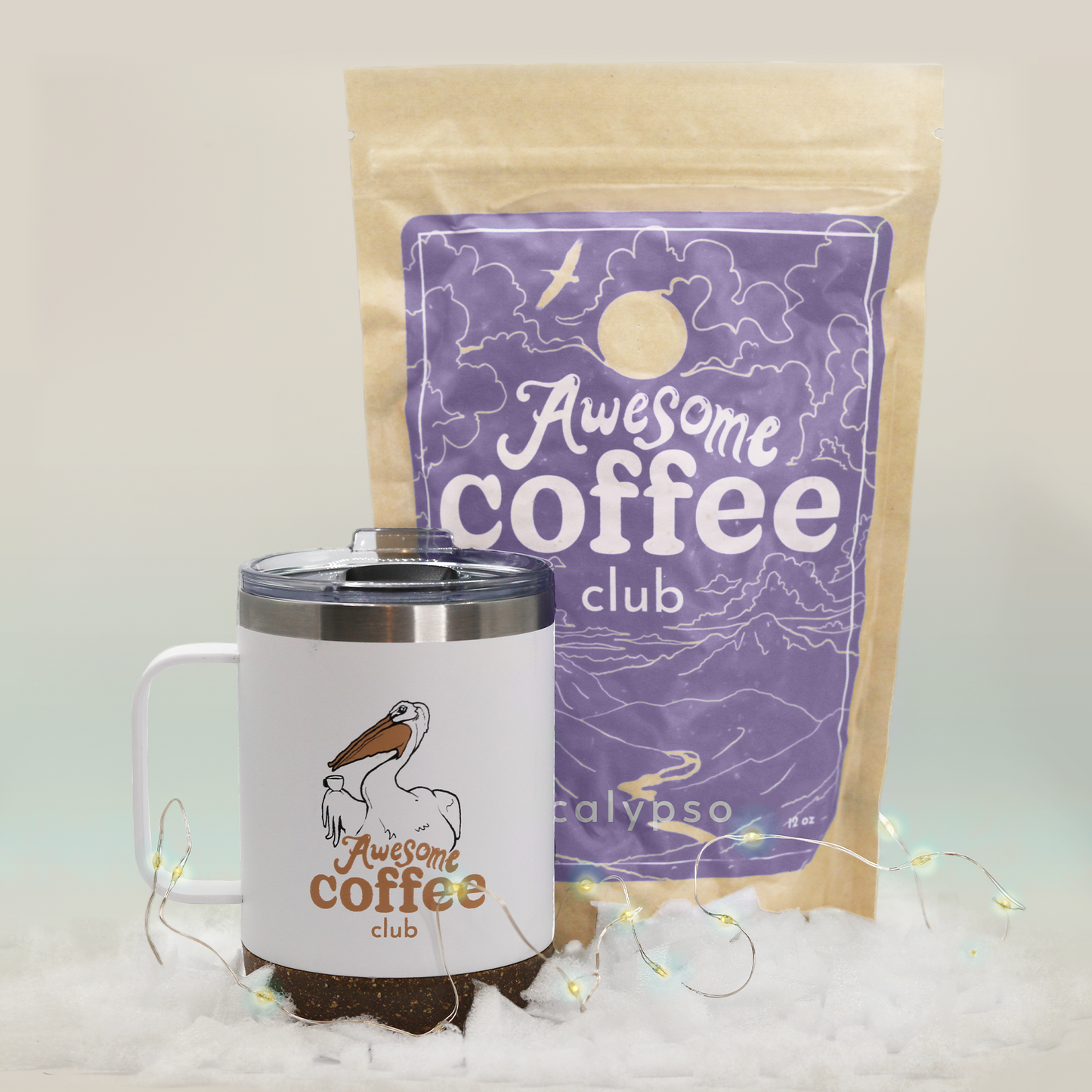 A bag of Calypso coffee from the Awesome Coffee Club with a light purple label sits behind a white travel mug with a pelican and the Awesome Coffee Club logo. A Good Store product.