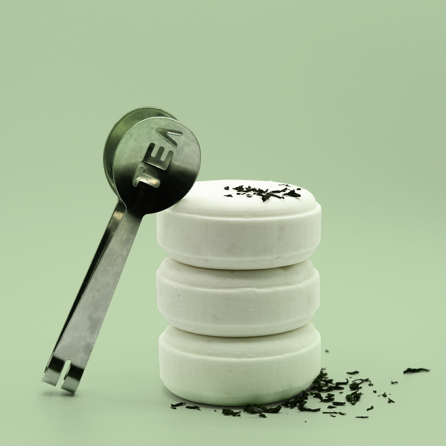 Three bath bomb pucks are stacked on top of each other. On one side is a little spoon that reads "tea". A Good Store subscription product.