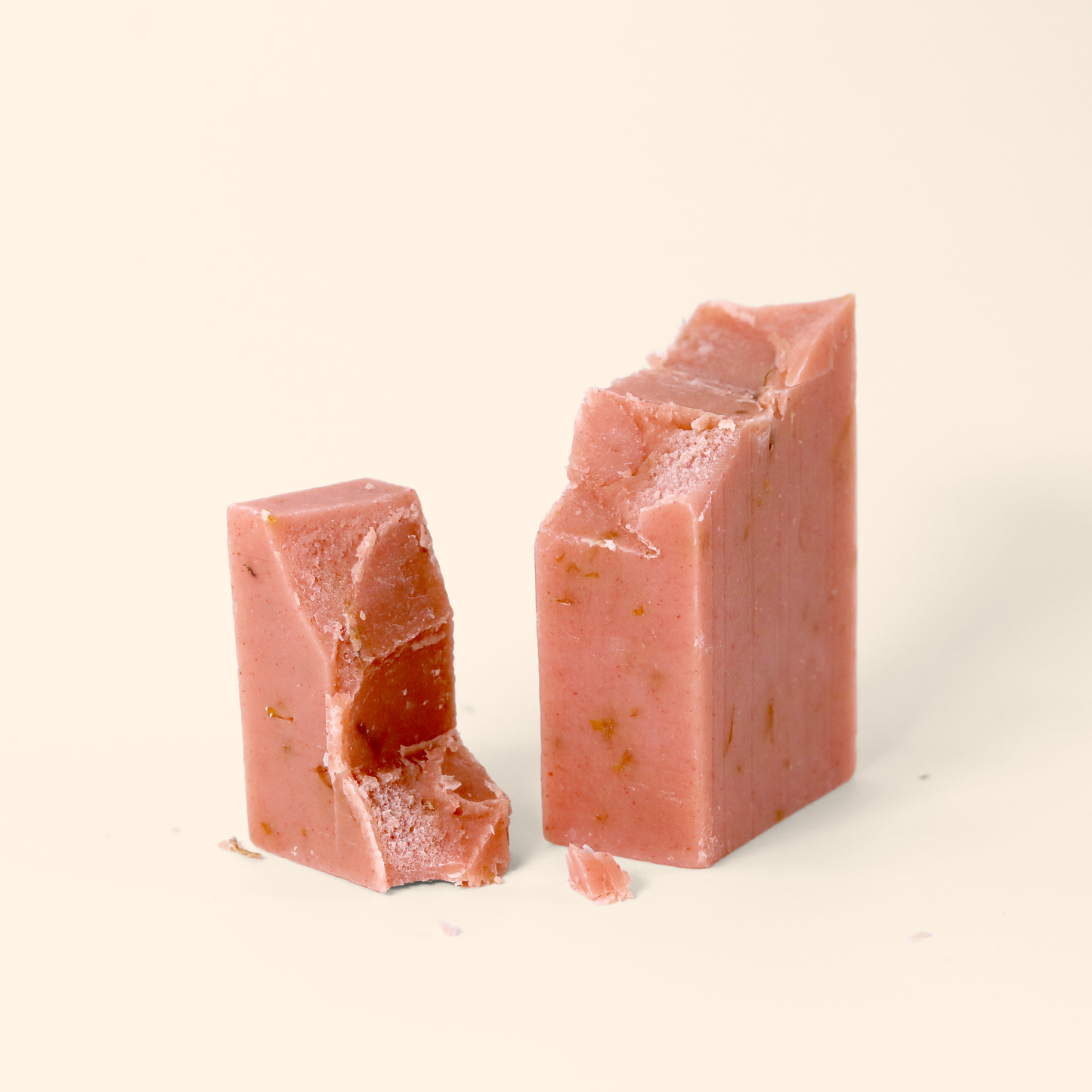 Two pink rectangular blocks of Daydreamer soap on a white surface broken in half. The soap has a matte, slightly textured appearance with small specks visible throughout. Sun Basin Soap - Good Store.