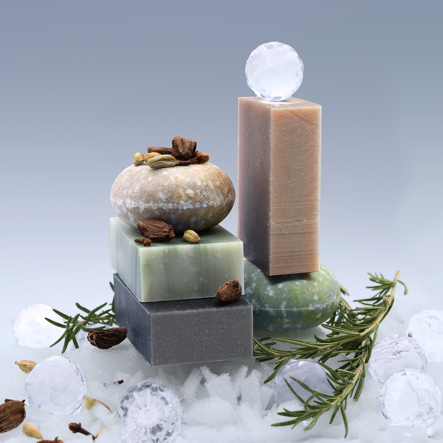 Three bars of the Sun Basin Soap holiday scents are piled up with the two shampoo cars atop rosemary springs, snow, glass balls and cardamon. A Good Store product.