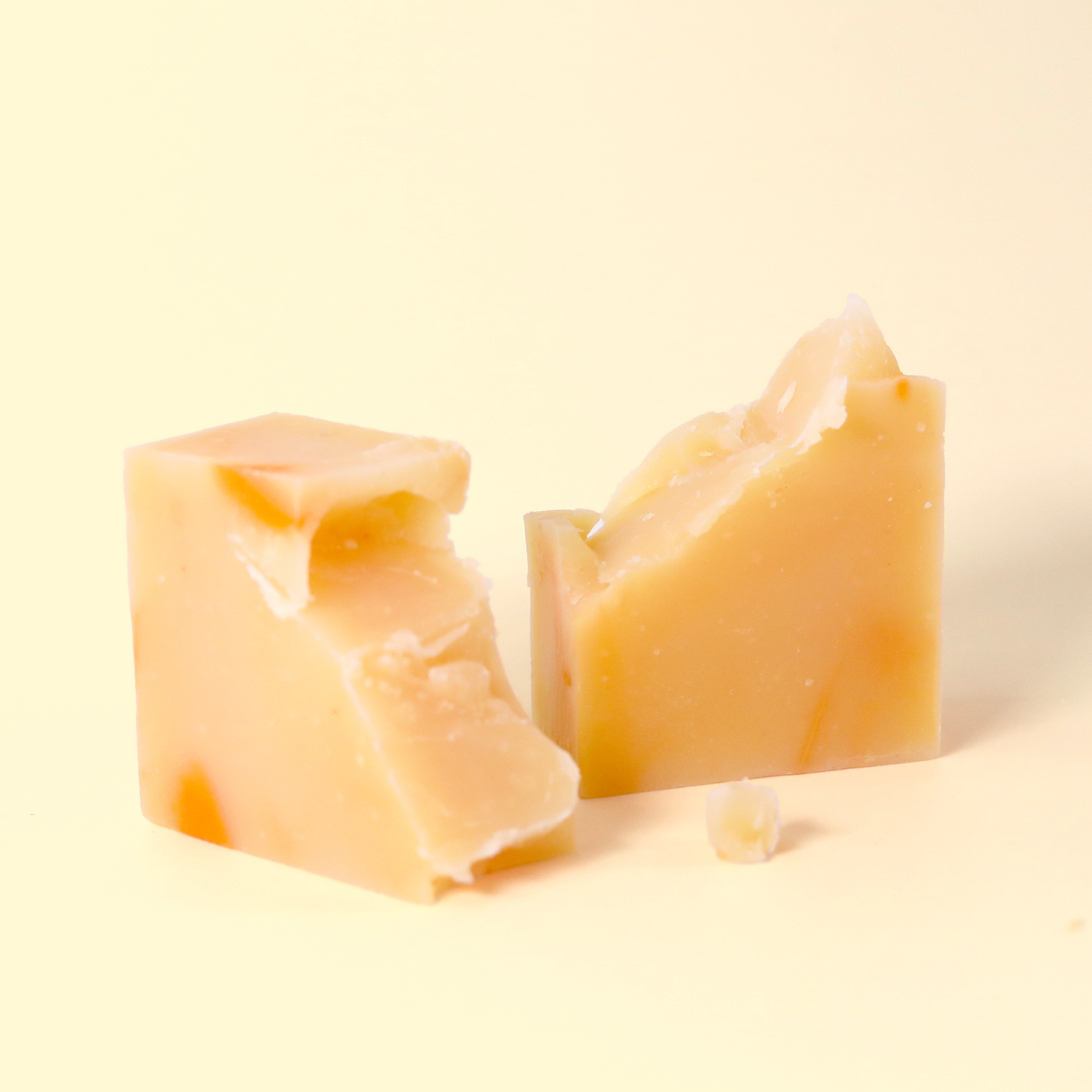Two chunky pieces of pale yellow soap with irregular cuts and textures on cream-colored background. Sun Basin Soap - Good Store.