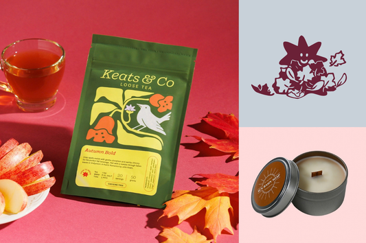 A bag of Keats & Co tea surrounded by fall leaves, sliced apples, and a mug of tea over a colorful background. Net to this image is a wooden wick candle and Good Store's mascot, Dot