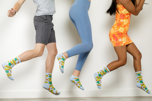 Image of three people jumping in the air all wearing different colorful clothing with matching socks