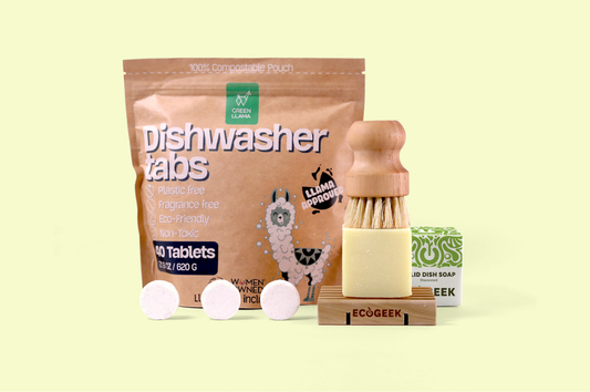 Image of an assortment of EcoGeek products including a solid dish soap, dishwasher tablets, and a bamboo dishbrush