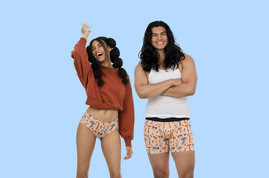 Image of two models wearing matching undies. One is a boxer cut, the other is a bikini cut, both are orange with mushroom designs on them.