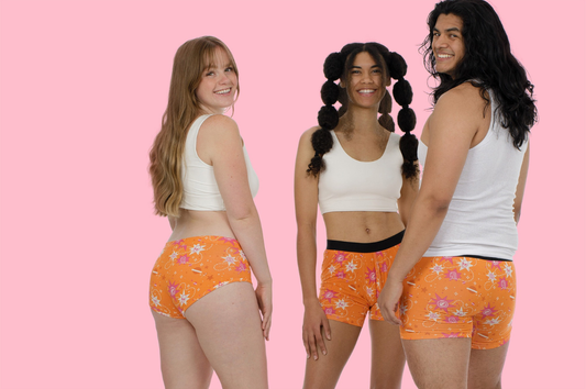 Three people wearing white shirts and orange undies from the Awesome Undies Club