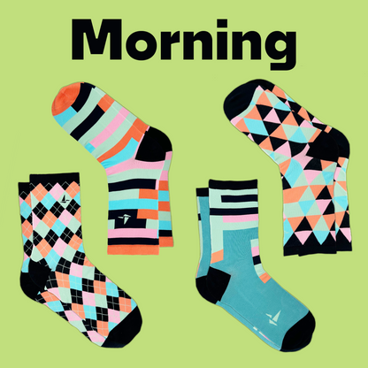 Four pairs of Hank's Cancer Socks in differing patterns with a similar color scheme lay in front of a light green background with text that reads "Morning". An Awesome Socks Club product.