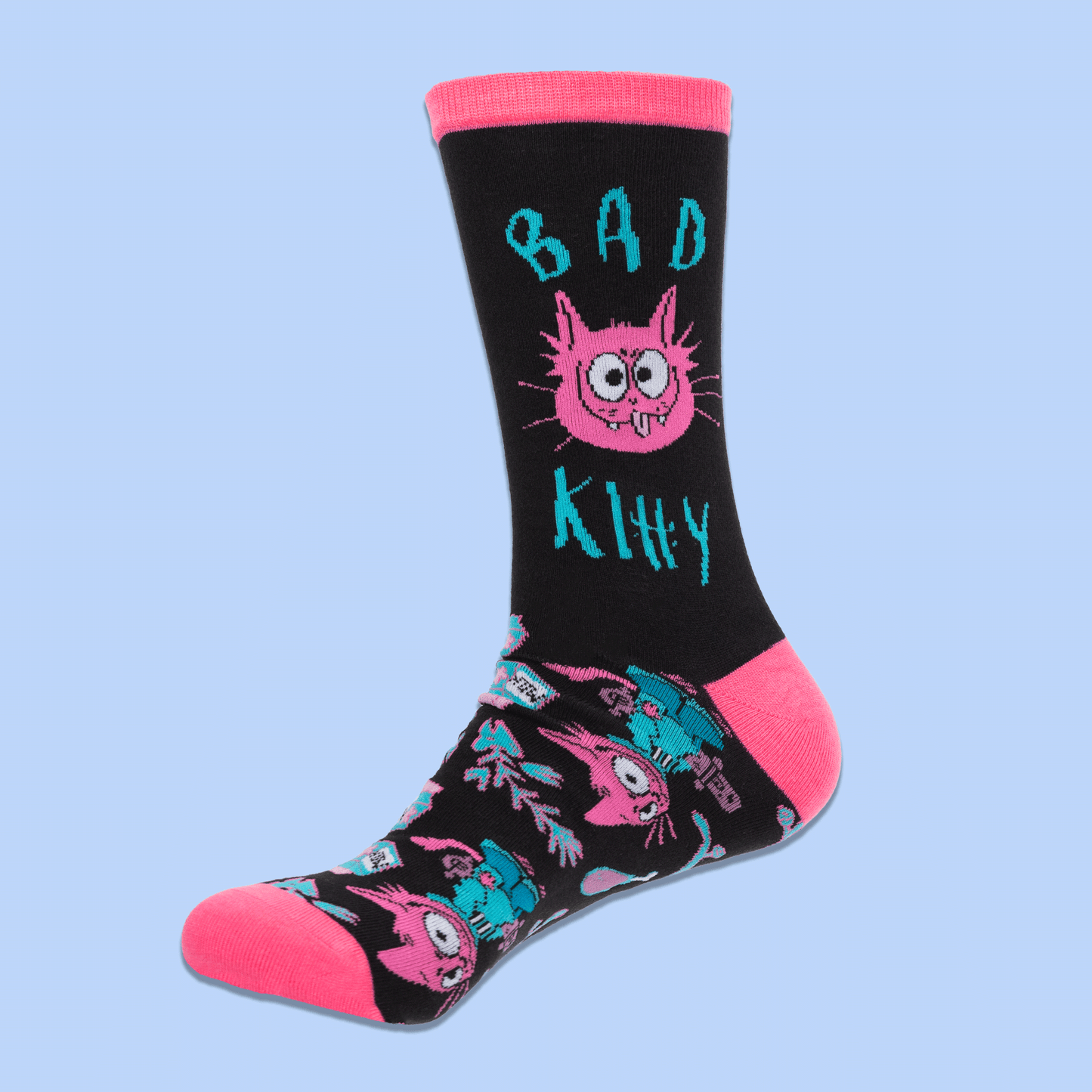 A pair of black crew socks with bright pink toes, heels, and cuffs, featuring a colorful cartoon cat and teal text and pattern details, displayed against a light blue background.