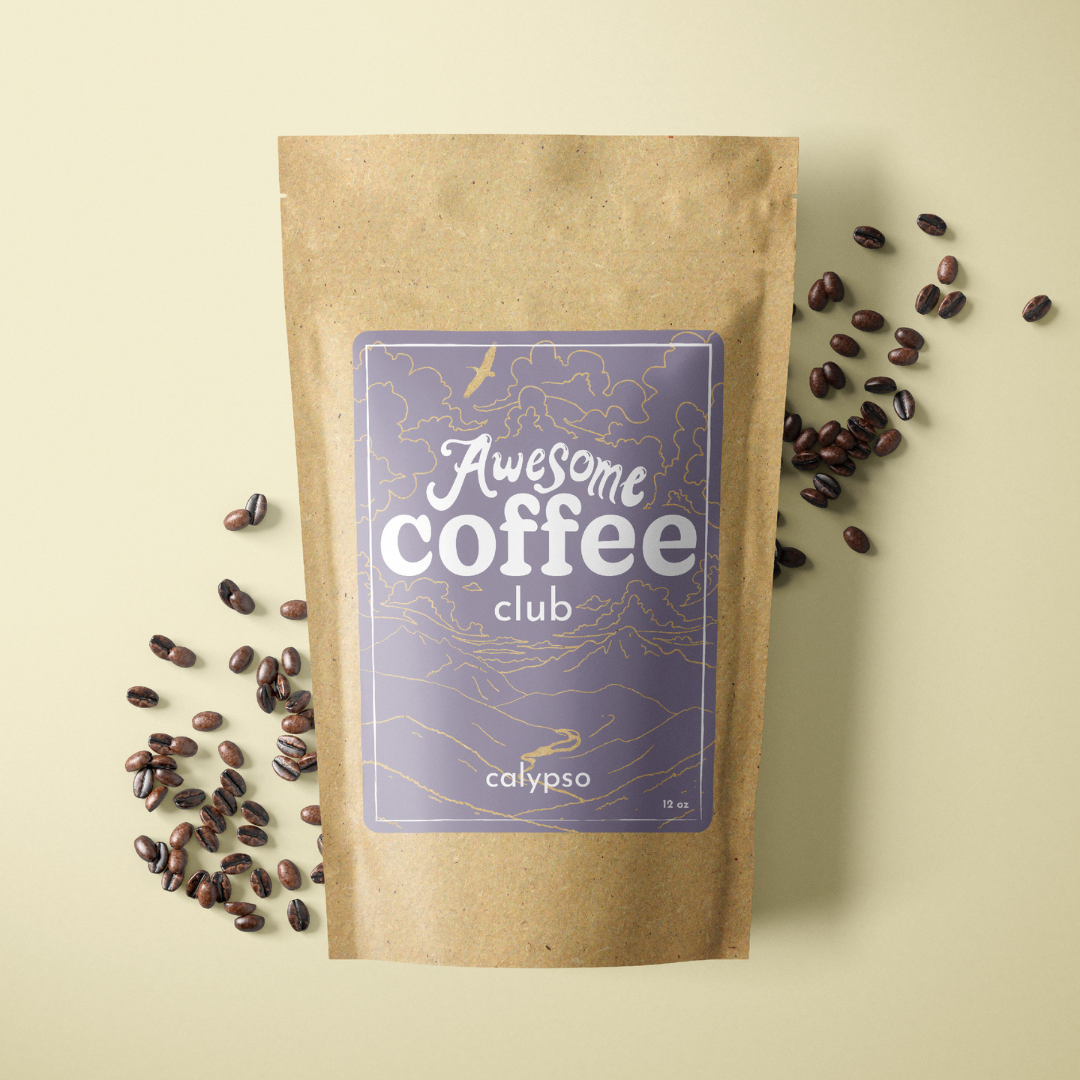A photo of a brown bag of coffee with a light purple label that shows a mountain scene and has the text "Awesome Coffee Club; Calypso". The bag sites atop a light green background with whole coffee beans spread around it. A Good Store subscription.