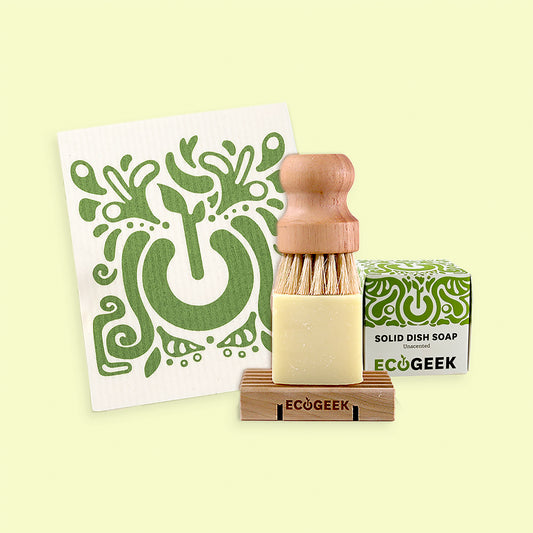 Solid dish soap bar with wooden brush and packaging on a light green background