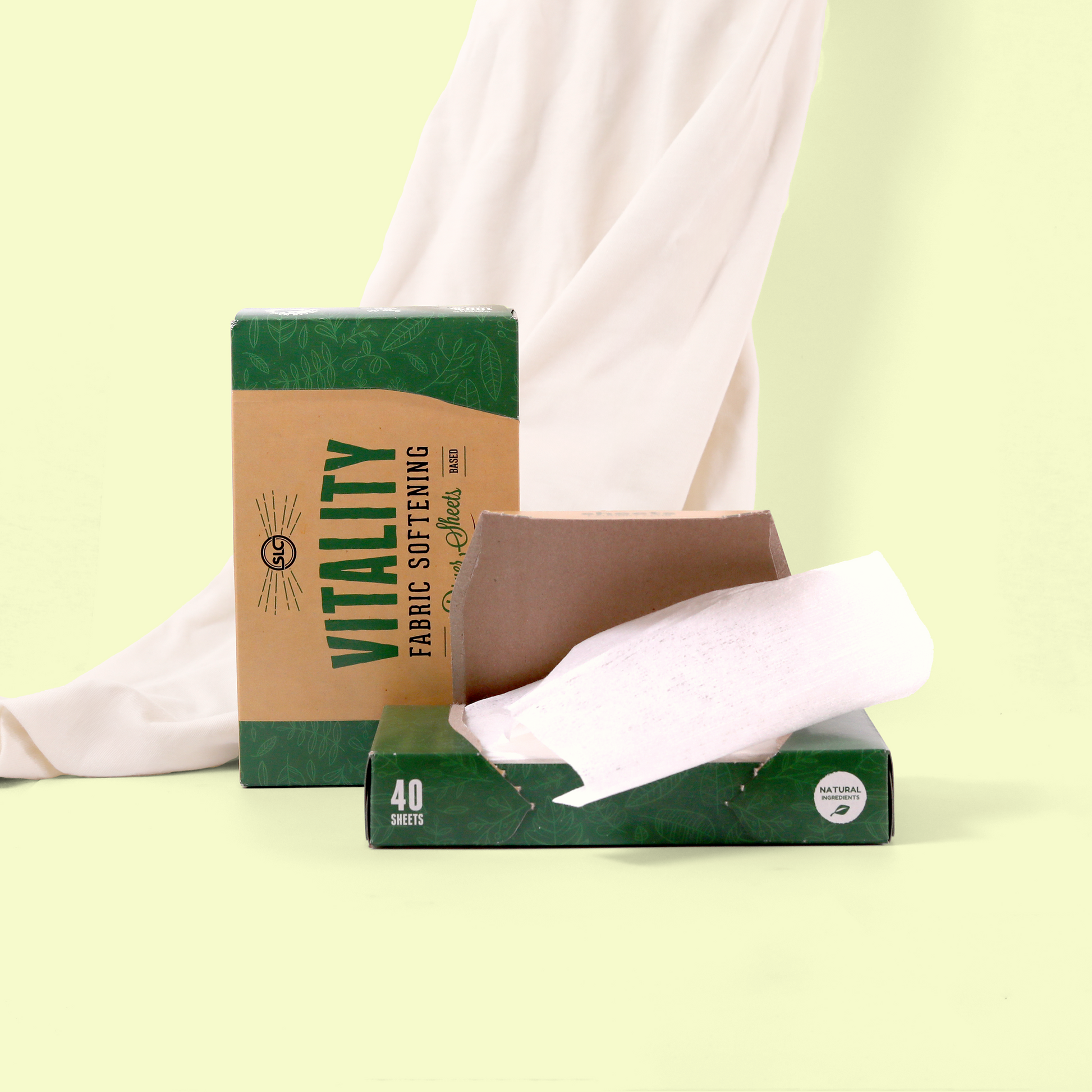 A styled product shot of "VITALITY" Fresh linen fabric softening dryer sheets against a white fabric backdrop. The green packaging indicates it contains plant-based dryer sheets. An open box shows the white sheet product partially pulled out. Dryer sheets from EcoGeek a Good Store product.