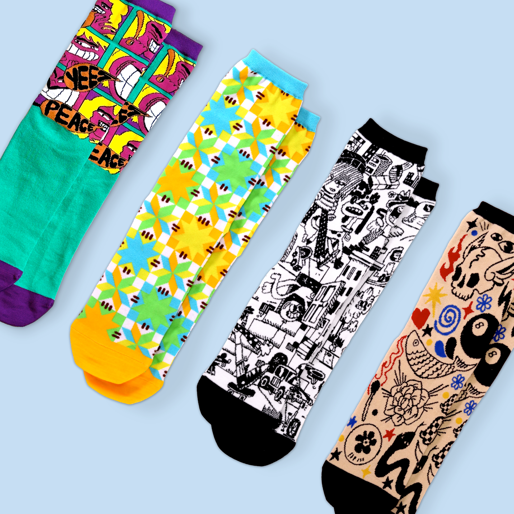 Four different patterned socks arranged diagonally on a light blue background. From left to right: a turquoise and purple sock with 'PEACE' text and pop art faces, a colorful sock with geometric flower patterns in yellow, blue, and green, a black and white sock with busy urban sketch designs, and a beige sock with tattoo-style artwork including skulls, flowers, and symbols in multiple colors. All socks are crew length and photographed flat