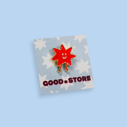 Blue background with orange Dot pin with gold outline with a pin on a backing with blue Dots with logo text Good Store. 