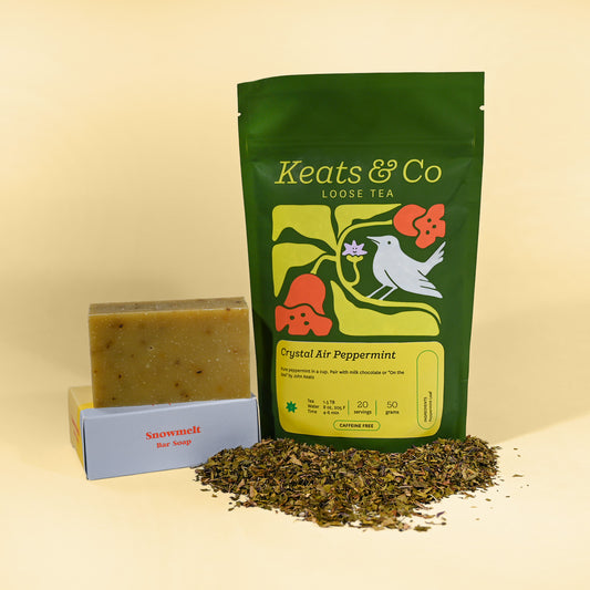 Keats & Co loose tea package with a bar of soap and tea leaves on a beige background