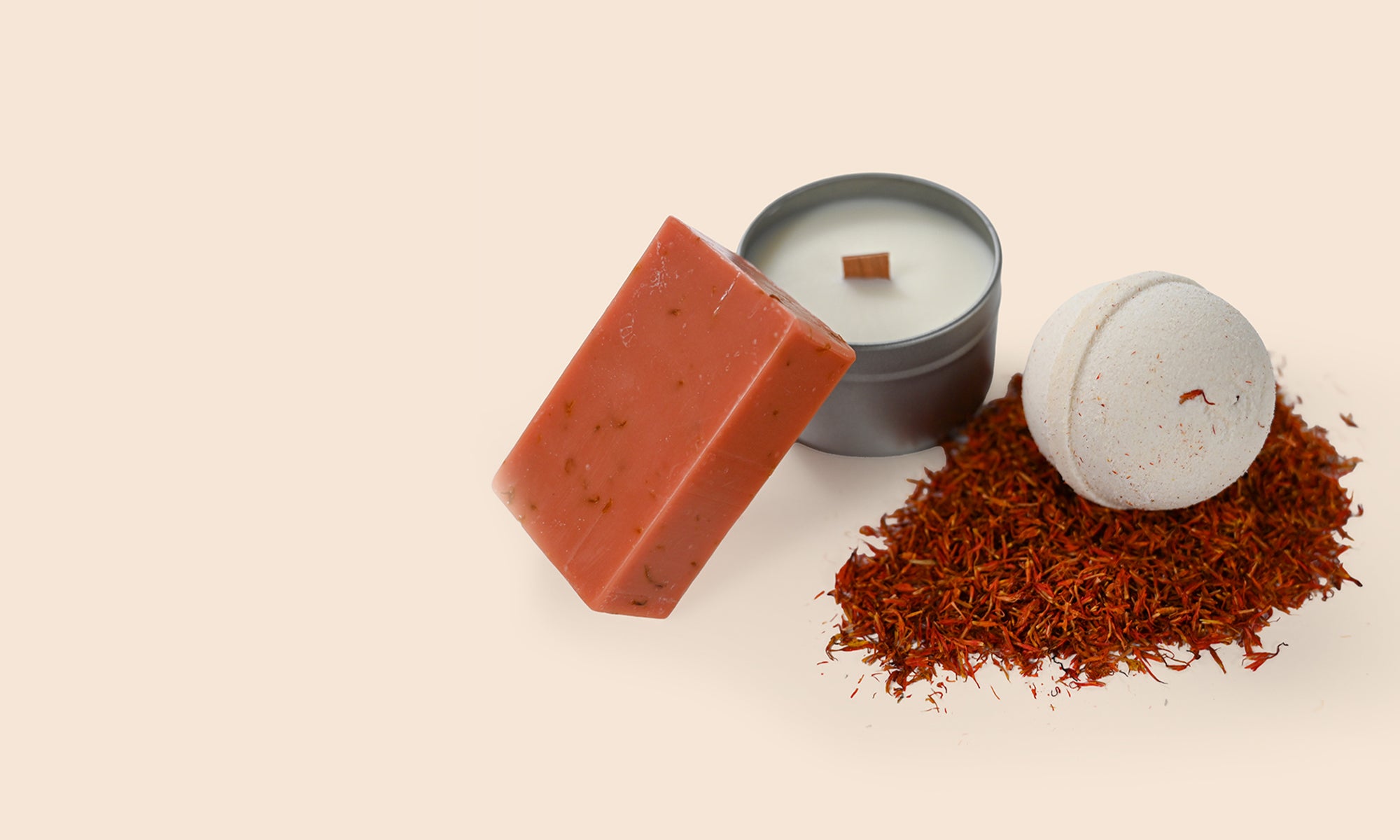 Bar of soap, candle, and a bath bomb on a beige background