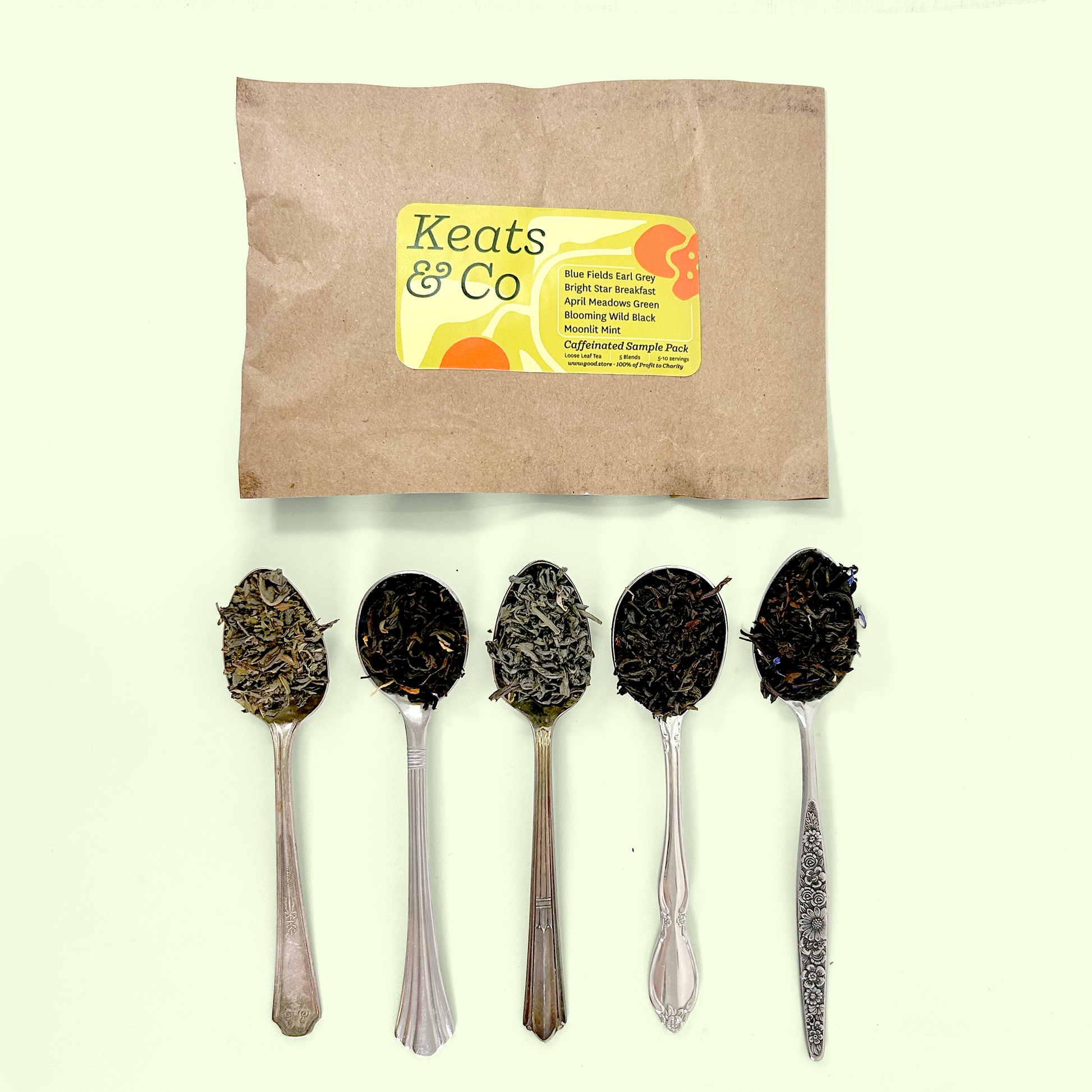 A Keats & Co tea sample pack in brown kraft paper packaging with a yellow label reading 'Caffeinated Sample Pack' listing varieties including Blue Fields Earl Grey, Bright Star Breakfast, April Meadows Green, Blooming Wild Black, and Moonlit Mint. Below the package are five silver spoons containing the corresponding tea samples, showing the variety from light green teas to dark black teas.