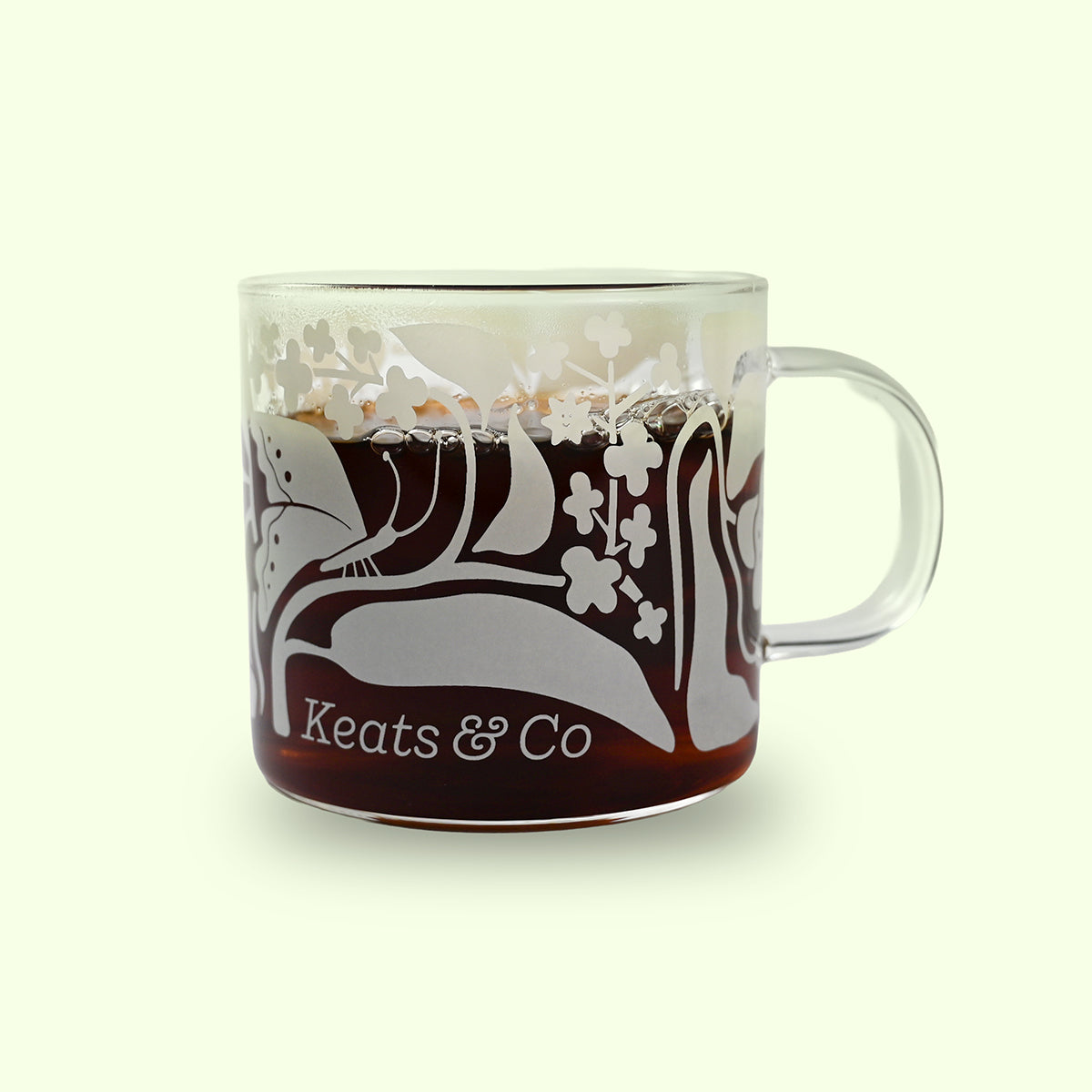 Clear mug with floral design and 'Keats & Co' text on a light green background