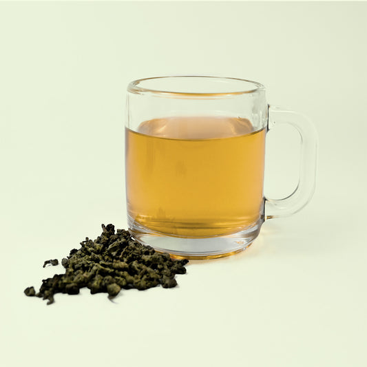 Photo of glass of tea with a light yellow tea with leaves of Oolong next to it. Part of the Keats & Co collection from Good Store. 