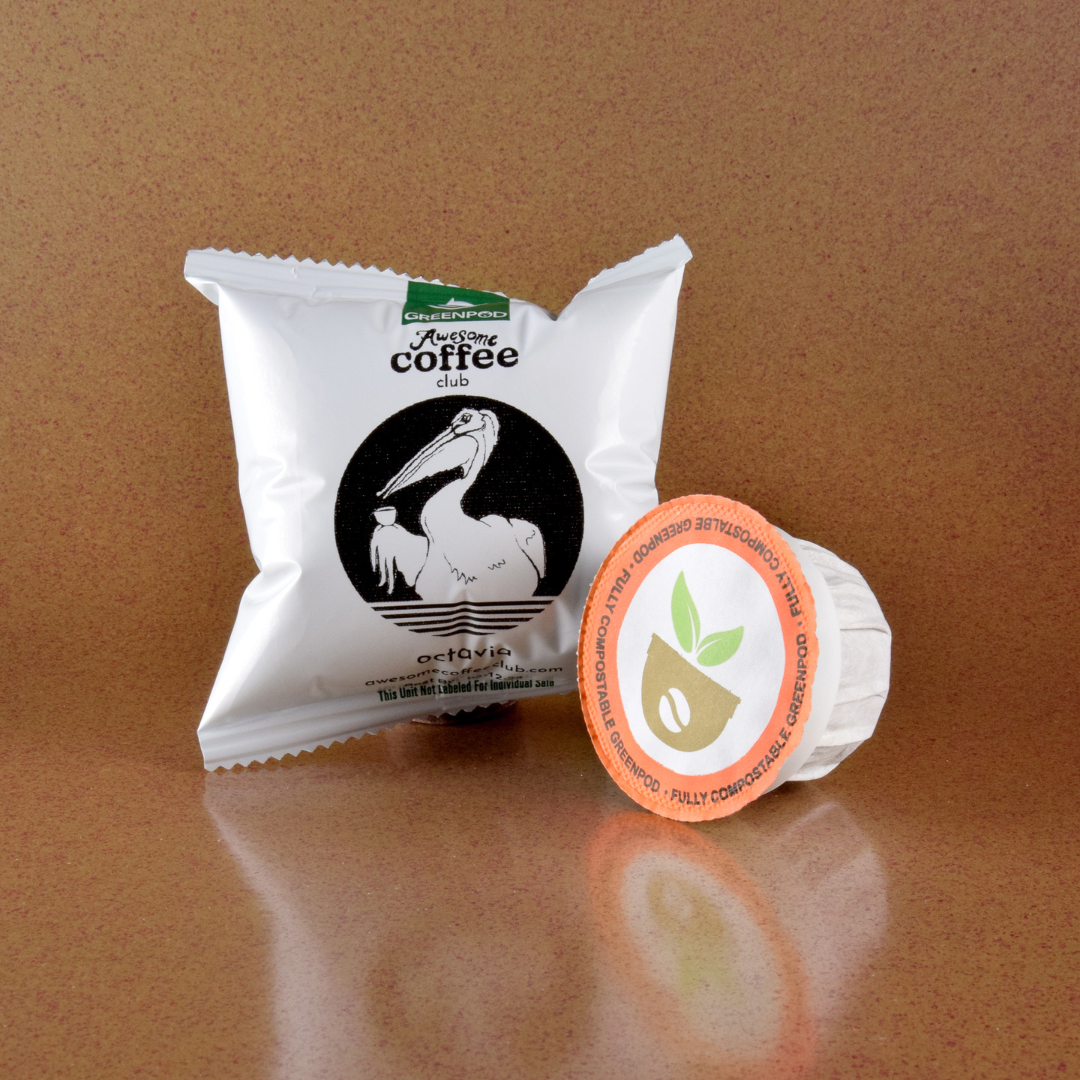 A coffee pod package with the Awesome Coffee Club logo with the pelican holding a cup of coffee. The coffee pod sits next to it that says "Fully Compostable Greenpod". A Good Store subscription product.