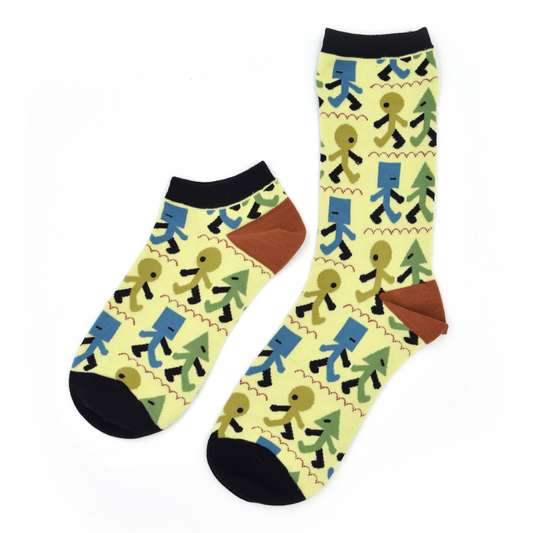 Two past designs from the Awesome Socks Club, one ankle, one crew, with a light green background and blue and green stick figure people with different shaped heads walking in a line. A Good Store product.