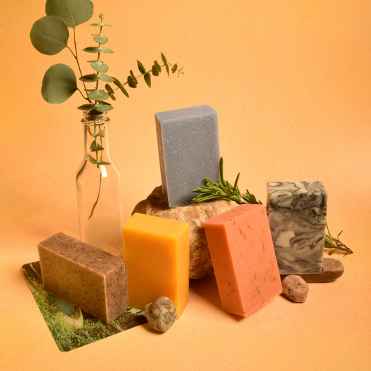 The five different scents and colors of Sun Basin Soap in front of a light orange background. A Good Store product.