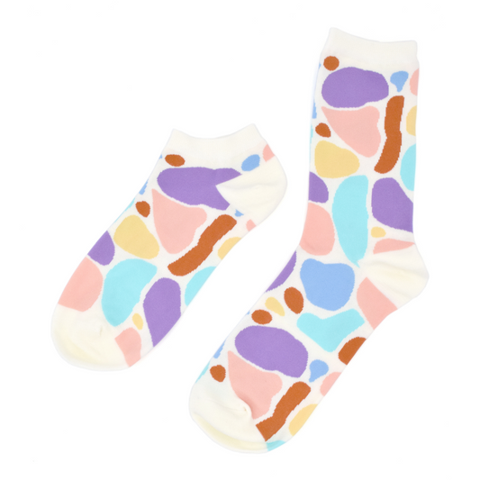 Two past designs from the Awesome Socks Club, one ankle, one crew, with a white background and colorful blobs. A Good Store product.