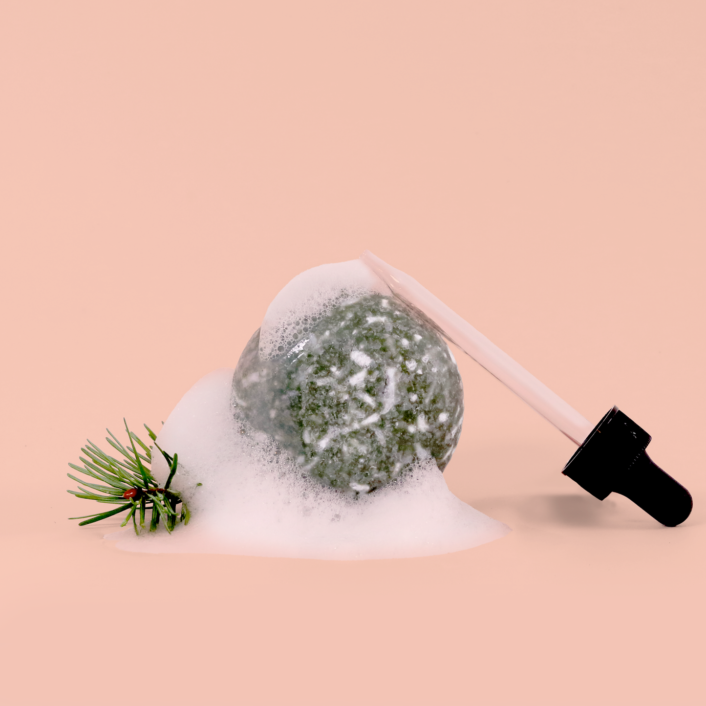 A shampoo bar in white foam or bubbles, with a small pine branch decoration and a black pump dispenser visible against a peachy pink background. 