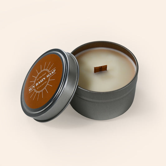 Candle in a tin container with a brown label on a beige background