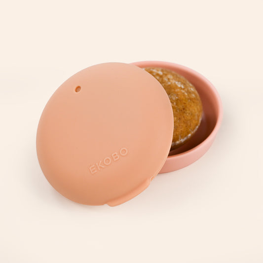 Pink shampoo bar travel case with a lid featuring the brand 'Ekobo' on a beige background