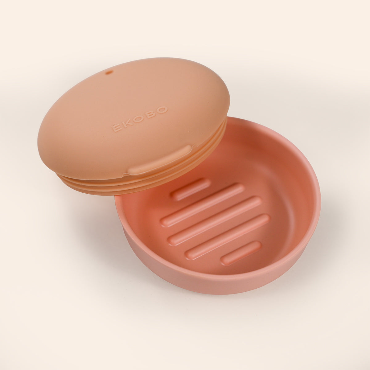 Blush soap dish with a lid on a light beige background